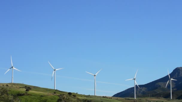 Turbinas eólicas de energía girando en la montaña con cielo azul — Vídeos de Stock