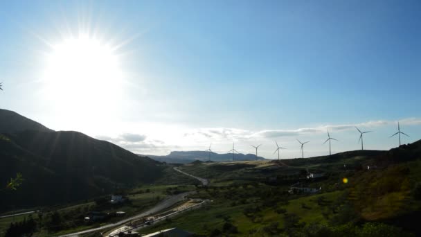 Rüzgar kuleleri enerji günbatımı arkadan aydınlatmalı, dağlarda — Stok video