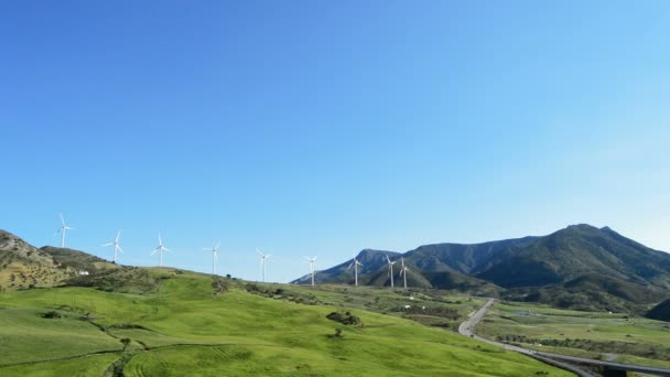 Landschaft der Windkraftanlagen erneuerbare Energien auf der grünen Wiese in den Bergen bei sonnigem Tag — Stockvideo