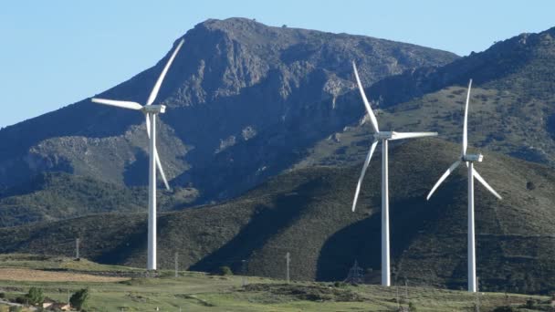 Windräder, Felder und Berge bei klarem Tag — Stockvideo