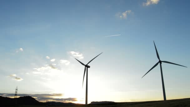 Turbinas eólicas energía en el campo que se mueve al atardecer — Vídeos de Stock