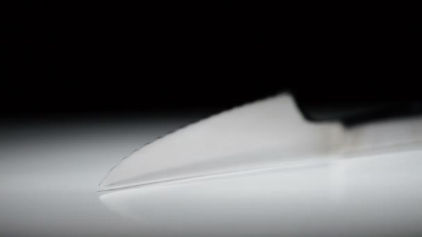 Metallkniv roterar på vit bas med svart bakgrund — Stockvideo