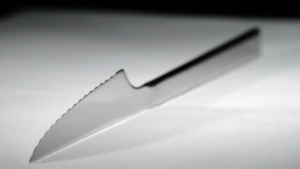 Couteau en métal tournant sur fond blanc avec fond noir — Video
