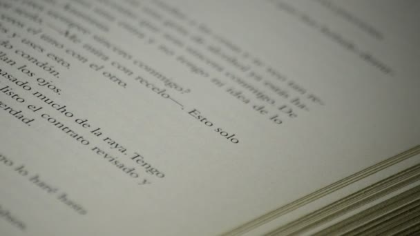 Тексты и слова паг бумаги открытой книги на испанском языке вращения на черном фоне — стоковое видео