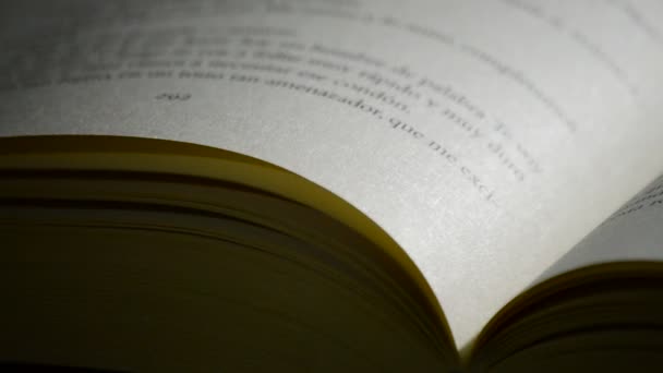 Pages et textes du livre ouvert tournant au fond noir 