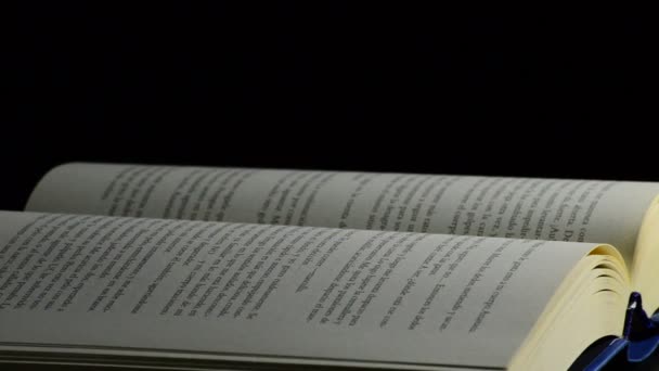 Stránky otevřené knihy rotují na černém pozadí — Stock video