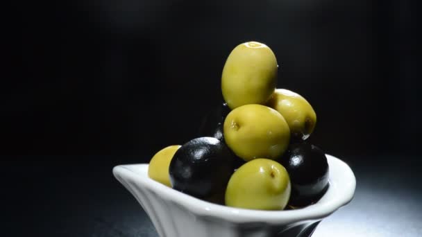 Aceitunas giroscopio verde y negro sobre fondo negro — Vídeos de Stock