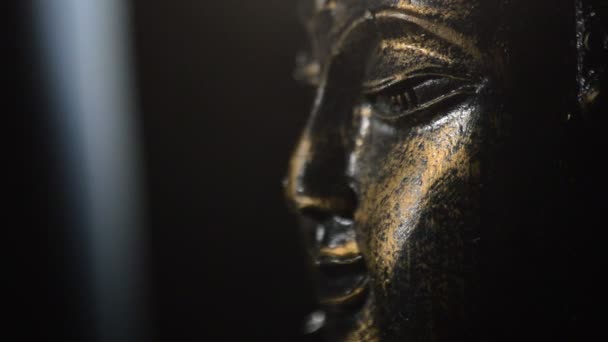 Будда лицо бюст, фигура буддист, вращающийся на черном фоне с дымом — стоковое видео