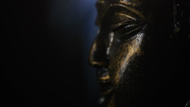 Busto de detalle de cara de buda, figura budista, girando en fondo negro con humo — Vídeos de Stock