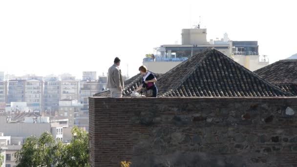 Touristen fotografieren in einer Mauer einer alten Burg bei Sonnenuntergang, la alcazaba, malaga, spanien — Stockvideo