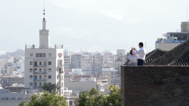 Mensen fotograferen van een gebouw in een mediterrane stad in de schemering van een uitkijktoren — Stockvideo