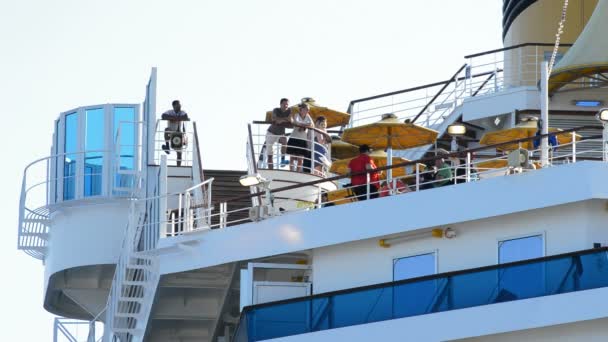 Cestující na terase velké lodi plavbu sledovat západ slunce — Stock video