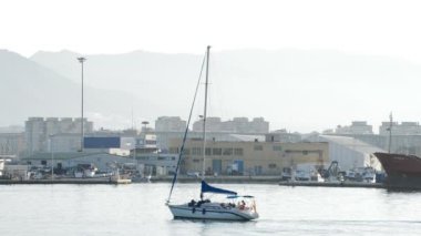 Küçük yelkenli tekne bir liman günbatımında gezinme