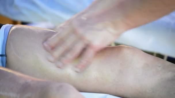 Physiotherapist massaging leg of an athlete — Stock Video