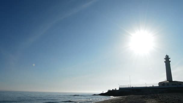 Panoramautsikt över stranden och havet fyr vid solnedgången — Stockvideo