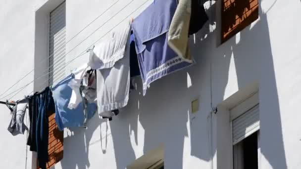 Kleding opgehangen om te drogen buiten een blok van appartementen of huizen — Stockvideo