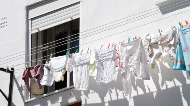 Kleidung zum Trocknen außerhalb eines Wohnblocks oder Hauses aufgehängt — Stockvideo
