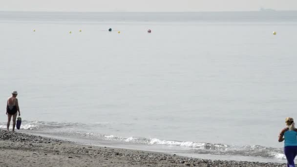 Vrouw lopen of joggen langs het strand door zee — Stockvideo
