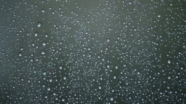 Bir oda cam cama düşen yağmur damlaları