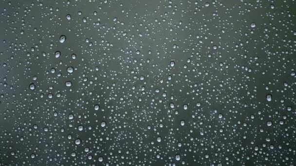 Gotas de lluvia cayendo sobre la ventana de cristal de una habitación — Vídeos de Stock