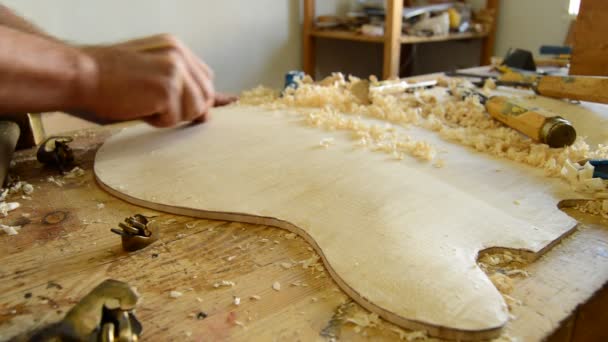 Luthier trabalhando no topo de um instrumento curvado — Vídeo de Stock