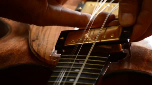 Luthier placing an electric guitar pickup in the workshop — Stock Video
