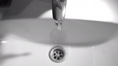 Beyaz banyo musluğu açıyorum.