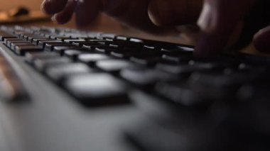 Siyah bir bilgisayar klavyesinde yazan parmaklar