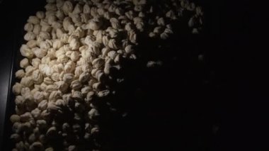 Siyah tepside çiğ bezelyeler, samimi bir ışıkla dönüyorlar.