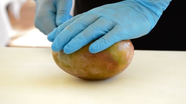 Руки шеф-кухаря, що ріже манго — стокове відео