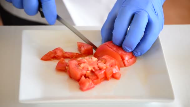 Chef-kok handen een tomaat snijden in kleine vierkantjes — Stockvideo