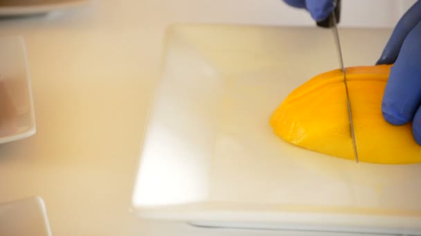 Chef-kok snijden een mango tropisch fruit pan — Stockvideo