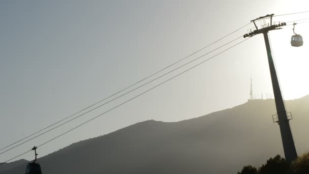 Ligne à câble avec passagers circulant au coucher du soleil — Video