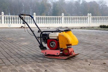 Vibrating plate compactor machine at a construction site. Equipment for soil thrombosis. Compaction work on sand, earth or asphalt clipart