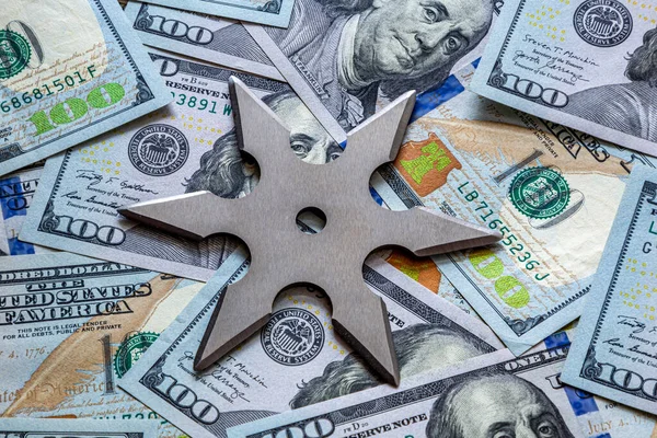 Shuriken Throwing star on a dollar background. Ninja weapons.