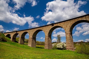 Güneşli bir günde baharda eski demiryolu taşından viyadük. Ukrayna 