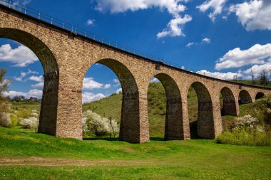 Güneşli bir günde baharda eski demiryolu taşından viyadük. Ukrayna 