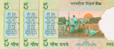 5 Rupi Hindistan 'da gün doğumunda tarlayı süren bir traktörün resmi. Hindistan 'ın kağıt parası..