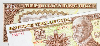 Kalaşnikof saldırı tüfeği taşıyan asker ve bayrakların 10 peso Küba resmi. Kâğıt para Küba.