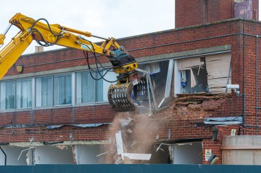 Uzun menzilli hidrolik çeneli eski bir binanın yıkımı. Yeni, modern bina için bir alanın yenilenmesi.