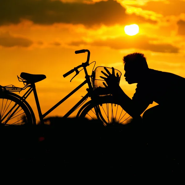 Silhueta de um homem beijando uma bicicleta — Fotografia de Stock