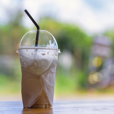 Plastik bardakta samanla buzlu kahve.