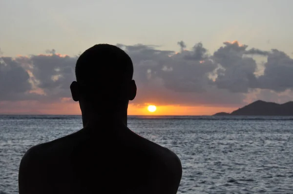 Silhouette of a head man from the back at sunset with the sea