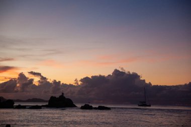 Deniz üzerinde harika bir gün batımı ve gölgede bir ada.