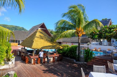La Digue Adası, Seyşeller, tropikal tatil köyü La Digue adası, palmiye ağacı ve güneşli bir günde yüzme havuzlu havuz manzaralı havuz.