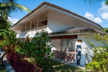 La Digue Adası, Seyşeller, tropikal tatil köyü La Digue adası, güneşli bir günde yemyeşil manzaralı daireler.