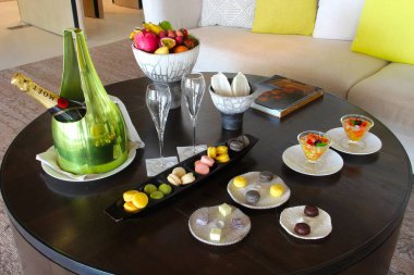 Milan, Italy- 29 Nisan 2014: Çeşitli tatlılar, çikolatalar ve bir şişe şampanyayla süslü koyu ahşap masa seti