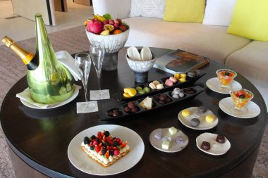 Milan, Italy- 29 Nisan 2014: Çeşitli tatlılar, çikolatalar ve bir şişe şampanyayla süslü koyu ahşap masa seti