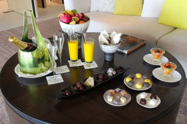 Milan, Italy- 29 Nisan 2014: Çeşitli tatlılar, çikolatalar ve bir şişe şampanyayla süslü koyu ahşap masa seti