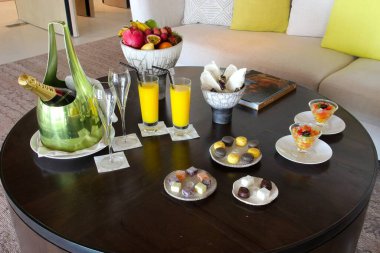 Milan, Italy- 29 Nisan 2014: Çeşitli tatlılar, çikolatalar ve bir şişe şampanyayla süslü koyu ahşap masa seti